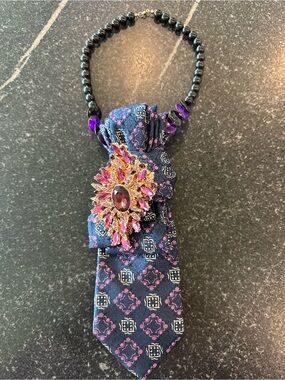 Navy Blue Patterned Tie Necklace with Pink Gem Brooch  on black beads.